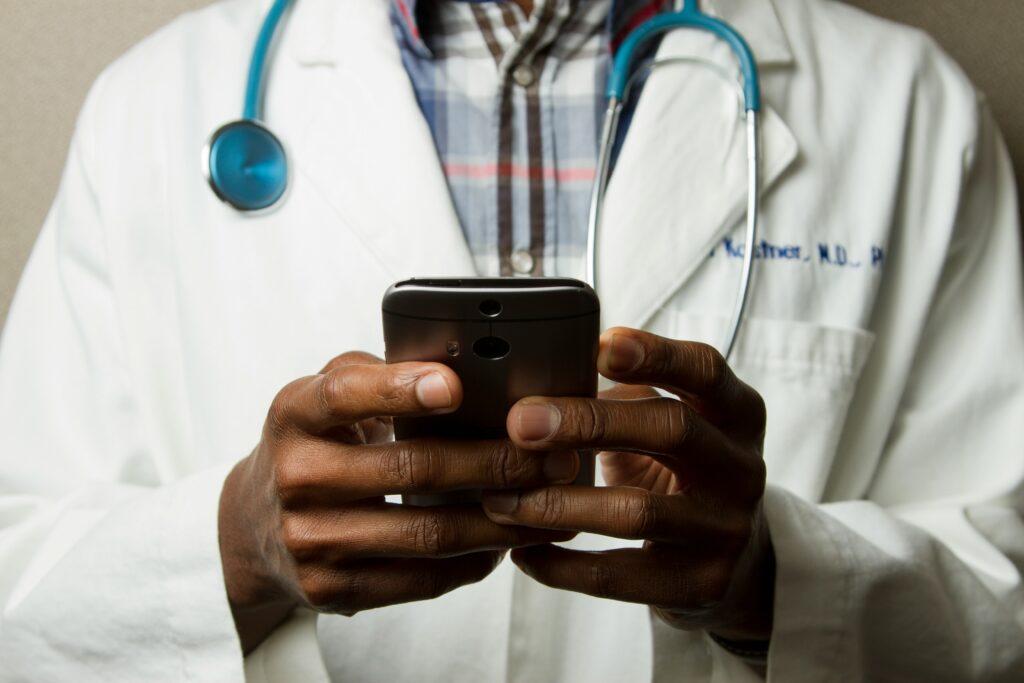Doctor holding a smartphone using healthcare messaging for patient communication